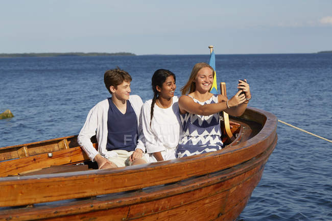 Amis sur le bateau prenant selfie dans l'océan bleu — Photo de stock