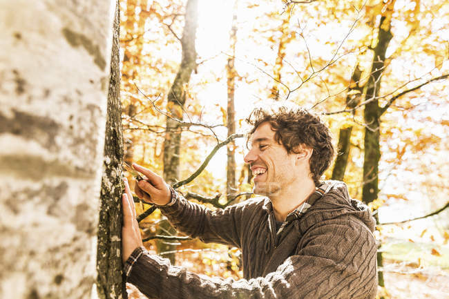 Man carving into tree trunk with penknife — Stock Photo