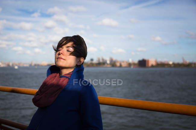 Woman on ferry in urban harbor — Stock Photo