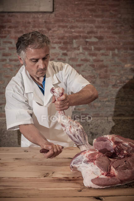 Metzger schnitzt Fleisch im Laden — Stockfoto