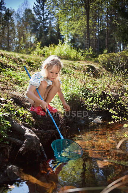 Дівчина риболовля з сіткою в струмку — стокове фото