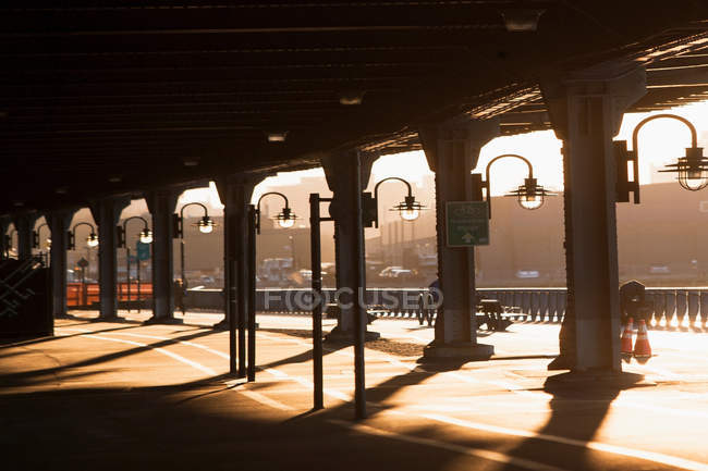 Sombras e lampiões abaixo da ponte ao pôr do sol — Fotografia de Stock