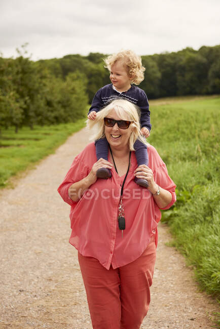 Бабушка с внуком на плечах — стоковое фото