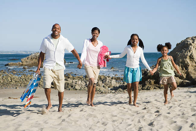 Familia afroamericana en una playa - foto de stock