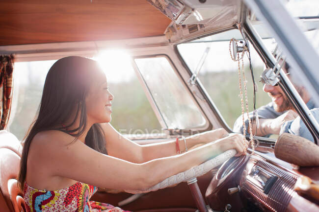 Mujer joven en autocaravana y sonriendo a su novio - foto de stock
