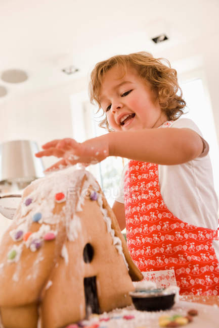 Молодий хлопчик випікає торт будинок — стокове фото