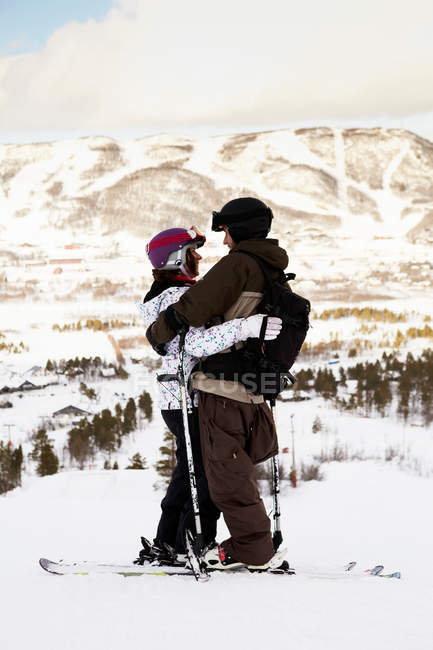 Esquiadores abraçando no topo da montanha, foco em primeiro plano — Fotografia de Stock