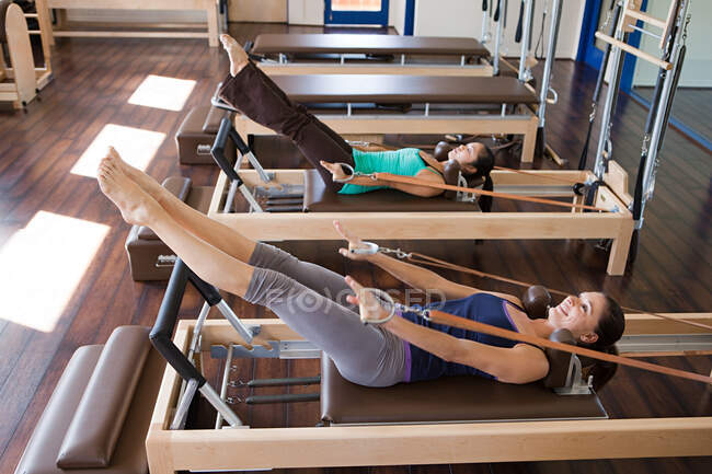 Deux femmes faisant des pilates dans la salle de gym — Photo de stock