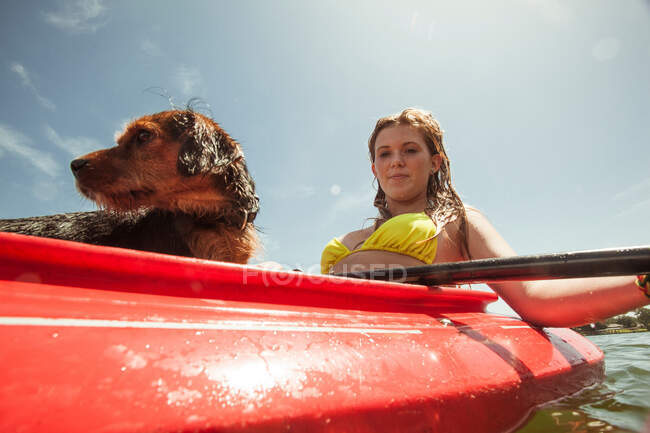 Teenager-Mädchen und Hund im Kajak — Stockfoto