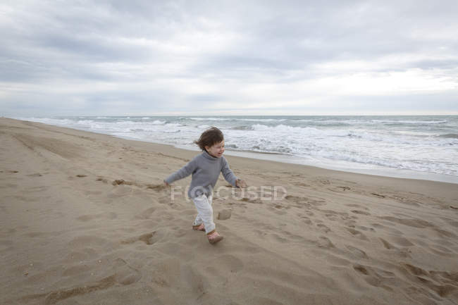 Девушка бежит по пляжу у океана — стоковое фото