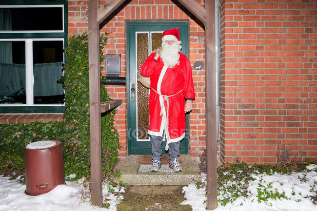 Homme habillé en Père Noël à l'extérieur de la maison — Photo de stock
