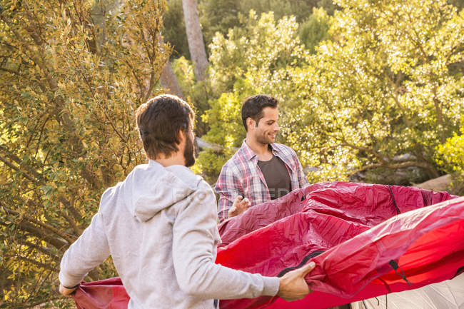 Two men putting up dome tent in forest, Deer Park, Cape Town, South Africa — Stock Photo