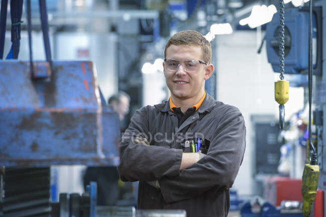 Portrait of engineering apprentice in engineering factory, smiling — Stock Photo