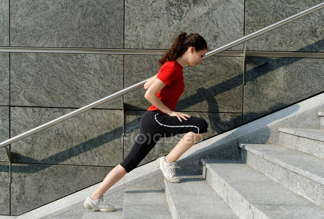 Mujer joven entrenando en escalera - foto de stock