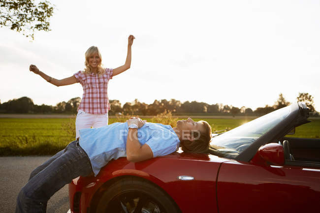 Casal relaxante na natureza em torno de um carro — Fotografia de Stock