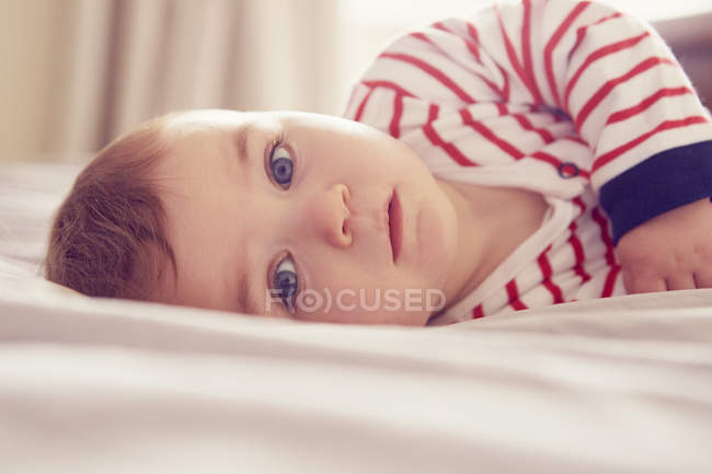 Дитячий хлопчик лежить на ліжку, вибірковий фокус — стокове фото