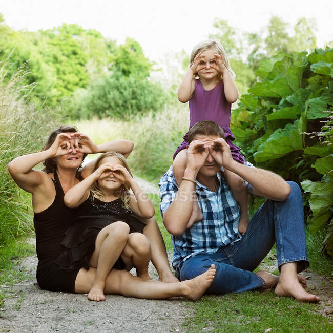 Familia haciendo caras en el camino de tierra, se centran en primer plano - foto de stock