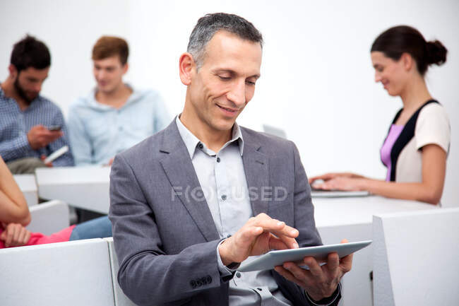 Homme mûr utilisant une tablette numérique — Photo de stock