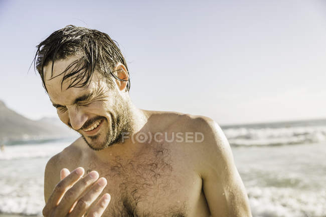 Hombre con el pelo mojado riendo en el mar, Ciudad del Cabo, Sudáfrica - foto de stock