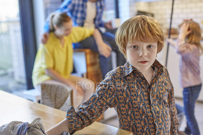 Мальчик вытирает обеденный стол, люди на заднем плане — стоковое фото