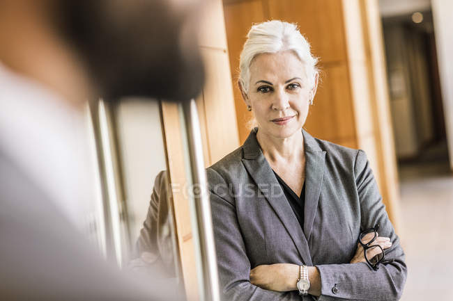 Businesswoman arms crossed looking at camera smiling — Stock Photo