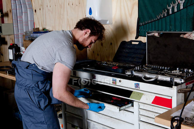 Mechaniker wählt Schraubenschlüssel aus Werkzeugkiste in Werkstatt — Stockfoto