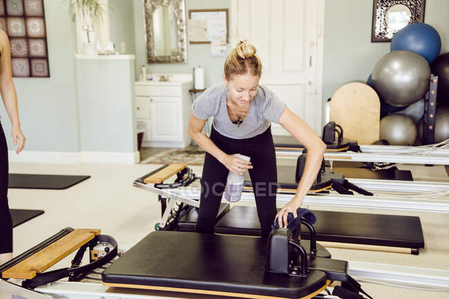 Women in gym cleaning pilates reformer — Stock Photo
