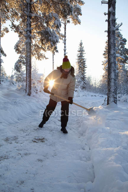 Mann schippt Schnee auf Feldweg — Stockfoto