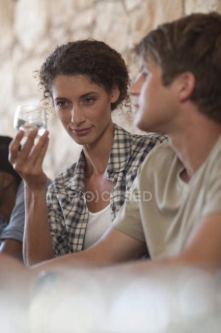 Man and woman sitting around table and tasting drinks — Stock Photo