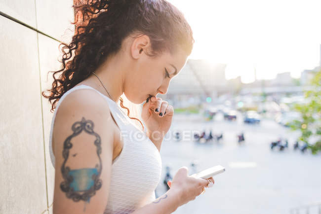 Side view of women looking down using smartphone, Milan, Italy — Stock Photo