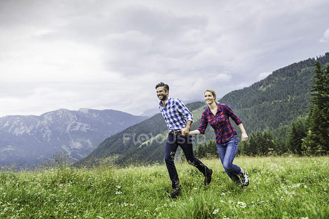 Couple holdings hands and running, Tirol, Áustria — Fotografia de Stock
