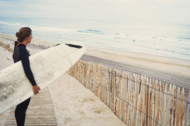 Surfista con tabla de surf en la playa, Lacanau, Francia - foto de stock