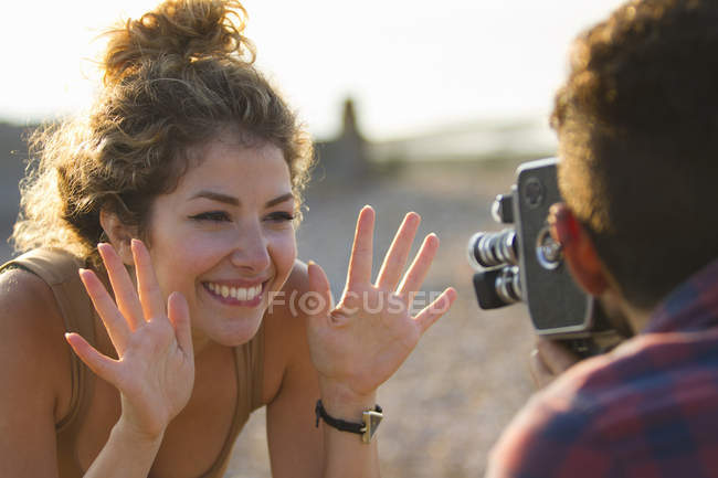 Young  woman posing for boyfriend with vintage camera — Stock Photo