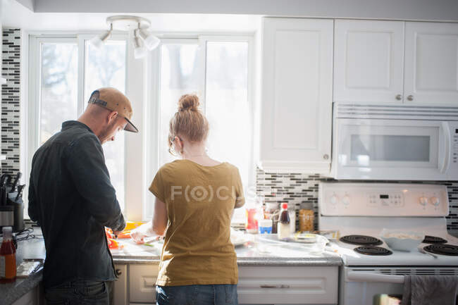 Casal adulto médio preparando comida na cozinha — Fotografia de Stock