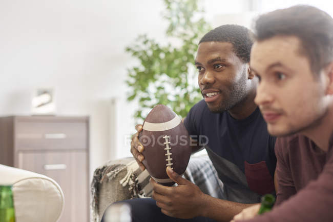 Männer sitzen in Lounge und halten Ball und schauen weg — Stockfoto