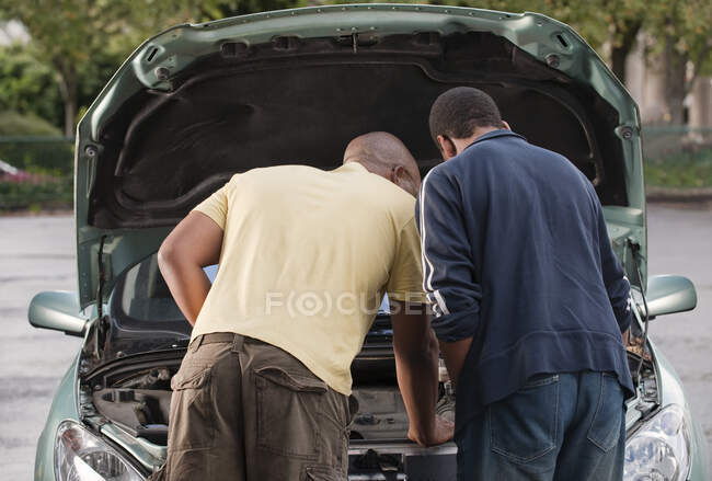 Padre & hijo trabajando en el coche - foto de stock