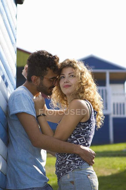 Молода пара обіймається пляжною хатинкою — стокове фото