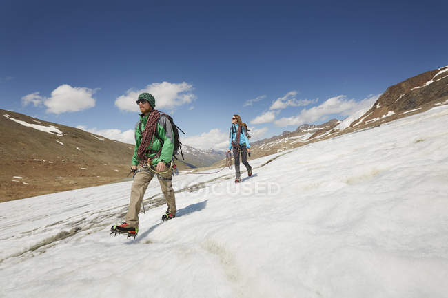 Young couple hiking down ice on Val Senales Glacier, Val Senales, South Tyrol, Italy — Stock Photo