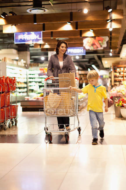 Женщина за покупками с сыном — стоковое фото