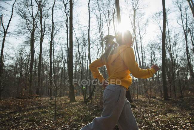 Young woman running in forest — Stock Photo