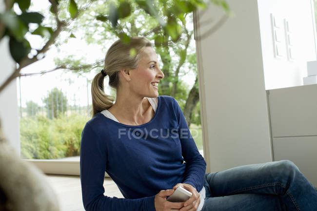 Mature woman holding cell phone — Stock Photo