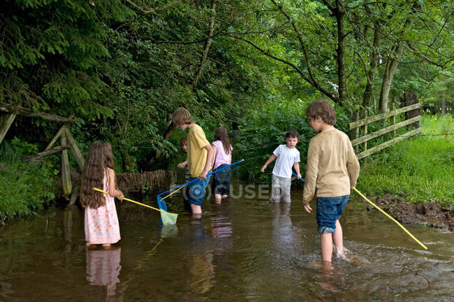 Дети рыбачат в реке — стоковое фото