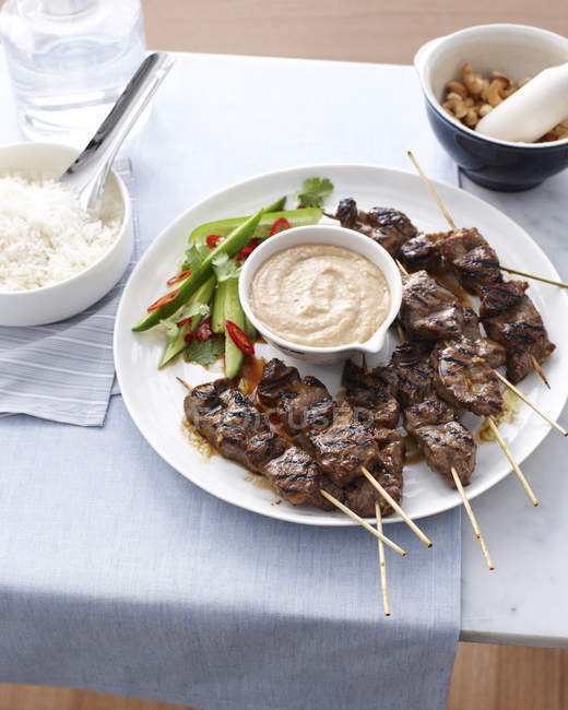 Still life of beef skewers and satay sauce — Stock Photo