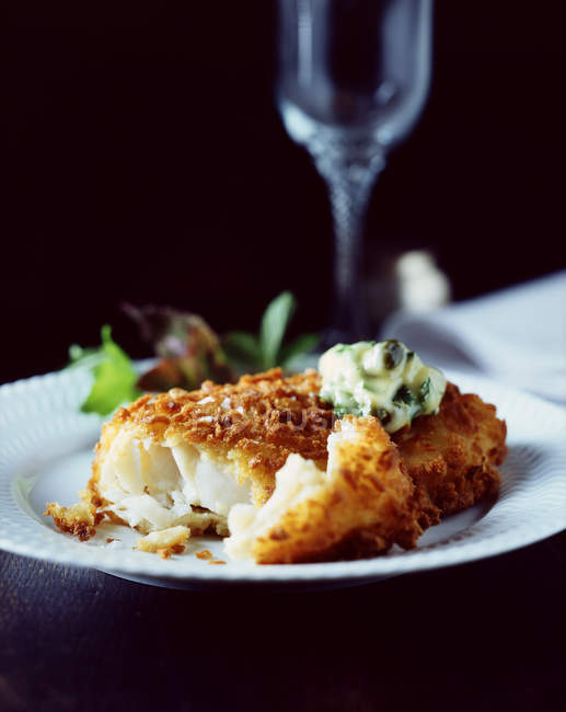 Хлібна риба з вершковим шпинатом і салатом на білій тарілці — стокове фото
