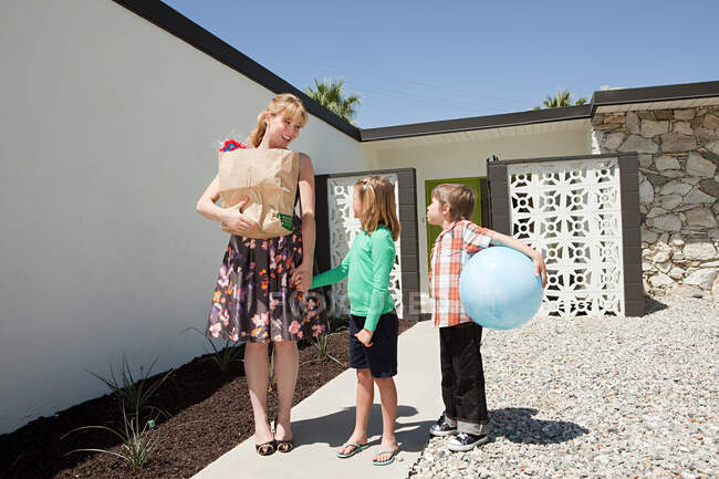 Mother with two children outside home — Stock Photo