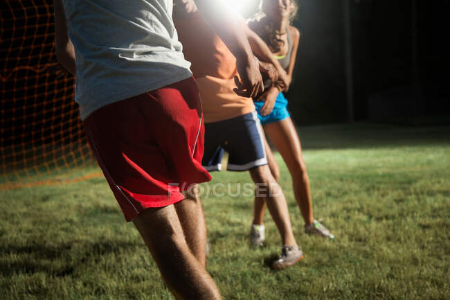 Amigos jugando al fútbol por la noche - foto de stock