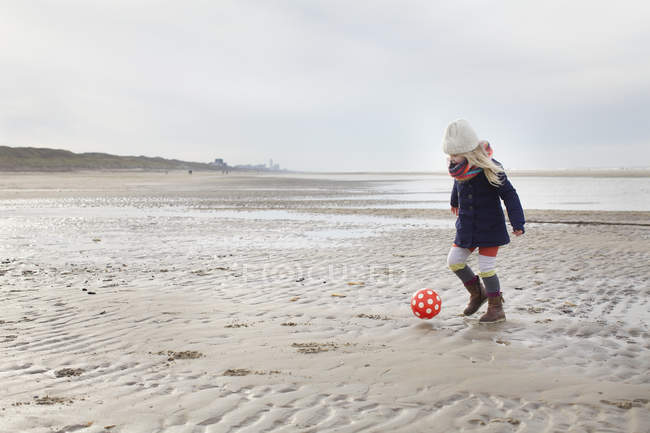 Menina de três anos jogando futebol na praia, Bloemendaal aan Zee, Países Baixos — Fotografia de Stock
