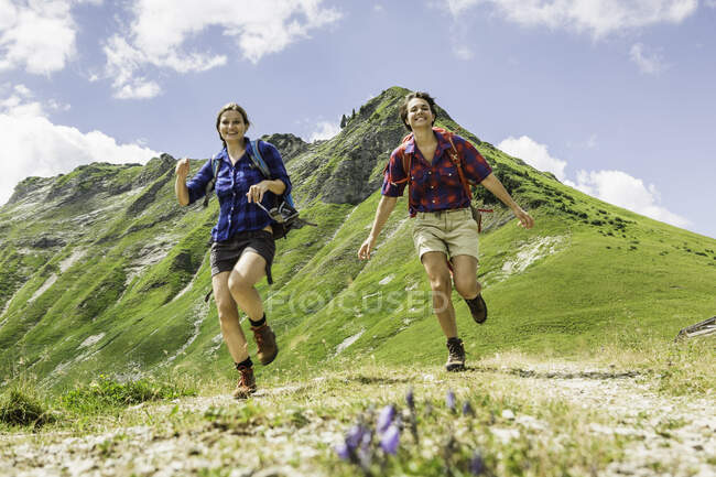 Two female friends running, Tyrol, Austria — Stock Photo