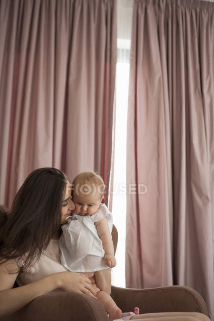 Madre jugando con el bebé en sillón - foto de stock