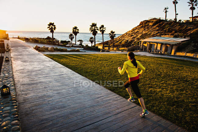 Woman running on wooden path — Stock Photo